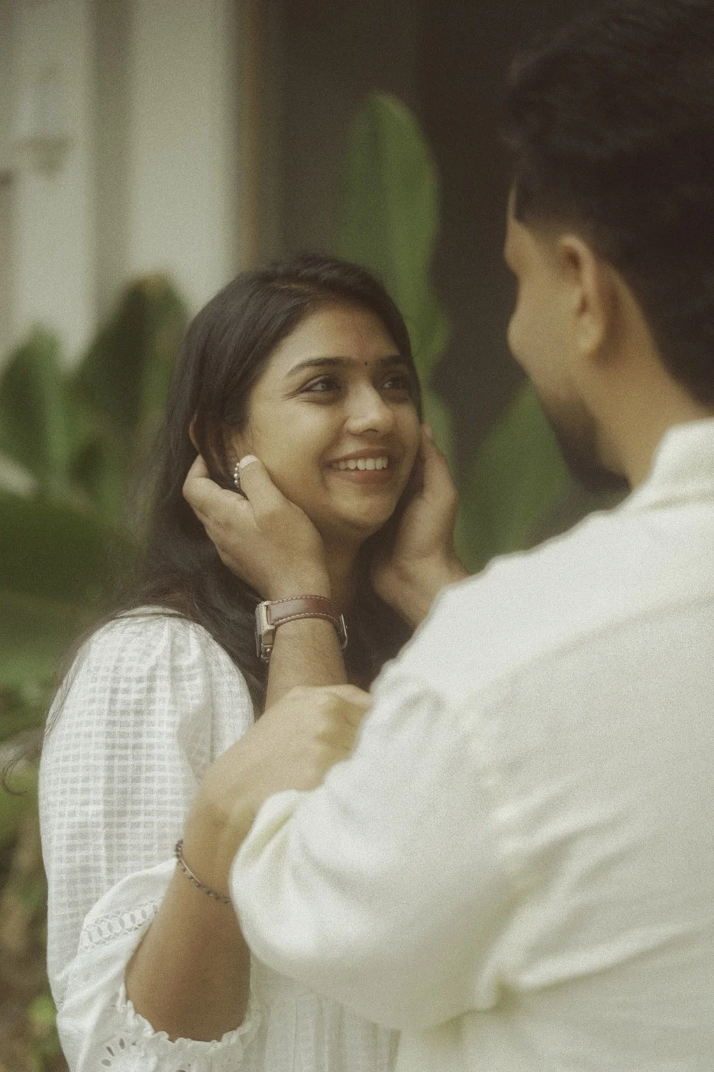 Induparvathi smiling as Abhilash holds her face